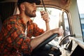 Communication by using radio. Young truck driver in casual clothes Royalty Free Stock Photo