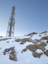 communications tower with mobile phone antennas on top of a snowy mountain, vertical Royalty Free Stock Photo