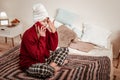 Communicative young lady in red cardigan touching her face