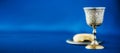 Communion still life. Unleavened bread, chalice of wine, silver kiddush wine cup on blue background. Christian communion concept Royalty Free Stock Photo