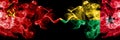 Communist vs Guinea Bissau abstract smoky mystic flags placed side by side. Thick colored silky smoke flags of Communism and