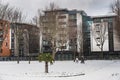 People, neighbourhood and lifestyle: community life captured as people talk and play with snow in a city park. Dublin, Ireland