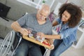 Community nurse with old disabled man on wheelchair Royalty Free Stock Photo