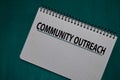 Community Outreach write on a book isolated on Office Desk