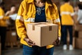 Community support: Close-up of volunteer holding box signifies local outreach and contribution.