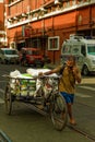 Commuter carrying goods on rickshaw while talking on phone