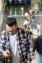 Commuter student man typing a message on the phone going up in e