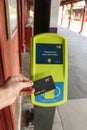 A commuter touching on a myki card reader at a train station platform to validate their ticket