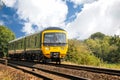 Commuter train approaching country pedestrian railway track crossing near Corton, Wiltshire, UK