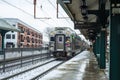 Commuter train leaving train station after snow.