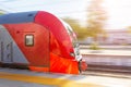 Commuter train travels at high speed through the passenger city station, head carriage, driver`s cab side view Royalty Free Stock Photo