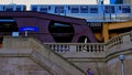 Man walks up stairs leading from Chicago Riverwalk to Wells Street as elevated `el` train passes on elevated track. Royalty Free Stock Photo