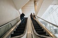 Commuters on an escalator inside a modern urban building space Royalty Free Stock Photo