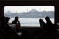 Commuters in a ferry in istanbul with hagia Sophia and Sultan Ahmet mosque