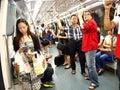 Commuters or passengers inside the MRT pass the time by playing games, watching videos, checking their email or updating their soc Royalty Free Stock Photo