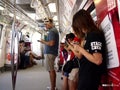 Commuters or passengers inside the MRT pass the time by playing games, watching videos, checking their email or updating their soc Royalty Free Stock Photo