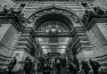 Commuters passing through the entrance of Waterloo train station at rush hour, one of the largest in London - monochrome