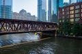 Commuters rush across the Lake Street bridge as bright summer morning light shines a spotlight on them in Chicago