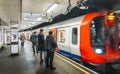 Commuters at Tower Hill Station on the London Underground with a fast-approaching train on the platform Royalty Free Stock Photo