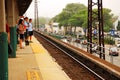 Commuters wait for their train on a platform