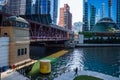 Commuters walk and ride the el amongst summer light and shadows in Chicago Loop