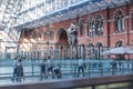 Commuters walking past the Meeting Place bronze sculpture at St Pancras International, London