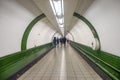 Commuters in white tunnel of metro station in London, UK