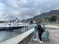Como, Italy - 12 november 2023: Man looks through a telescope at the sea standing on the shore at the foot of the Royalty Free Stock Photo
