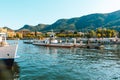 Como lake in city Como picturesque scenic view to blue water with white yachts and boats, mountains and city shore Royalty Free Stock Photo