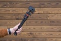 Compact action camera on a flexible tripod in hand on a wooden background Royalty Free Stock Photo