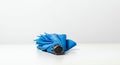 A compact, blue folding umbrella lies on a white surface against a plain background. The Royalty Free Stock Photo