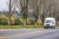 Small compact commercial transportation mini van driving on the straight local road Royalty Free Stock Photo