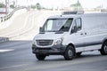 Compact commercial white mini van for cargo delivery and small business running on the city street Royalty Free Stock Photo