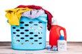 Compact concentrated laundry liquid detergent and regular liquid detergent next to basket full of apparels