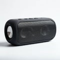 A compact, cylindrical black Bluetooth speaker featuring a metal mesh grille on the Royalty Free Stock Photo