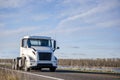 Compact day cab white big rig semi truck tractor without semi trailer running on the road along the Columbia River Royalty Free Stock Photo