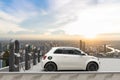 Compact electric car charging in the station of rooftop with city background, 3d render Royalty Free Stock Photo