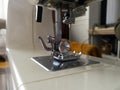 Compact electric sewing machine on the table in the living room