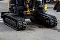 Compact excavator with rubber tracks parked on asphalt surface, Royalty Free Stock Photo