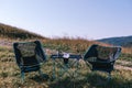 Compact folding chairs and a table, lightweight materials. Equipment for camping, tourism, active recreation. Summer sunny day.
