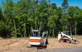 A compact front loader and mini excavator on dirt at home construction lot Royalty Free Stock Photo