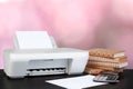 Compact home printer on desk with books against blurred background Royalty Free Stock Photo