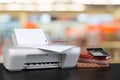 Compact home printer on desk with books against blurred background Royalty Free Stock Photo