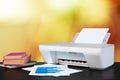 Compact home printer on desk with books against blurred background Royalty Free Stock Photo