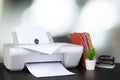 Compact home printer on desk with books against blurred background Royalty Free Stock Photo