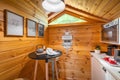 Compact kitchen with small round dining table in wooden house. Village life concept. Royalty Free Stock Photo