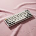 A compact mechanical keyboard is placed on a textured pink fabric surface Royalty Free Stock Photo