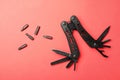 Compact portable black multitool and details on red background, flat lay Royalty Free Stock Photo