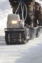 Compact snowmobile close up - motorcycle towing pulls cargo on snow countryside
