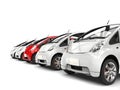 Compact white electric cars in a row - red stands out